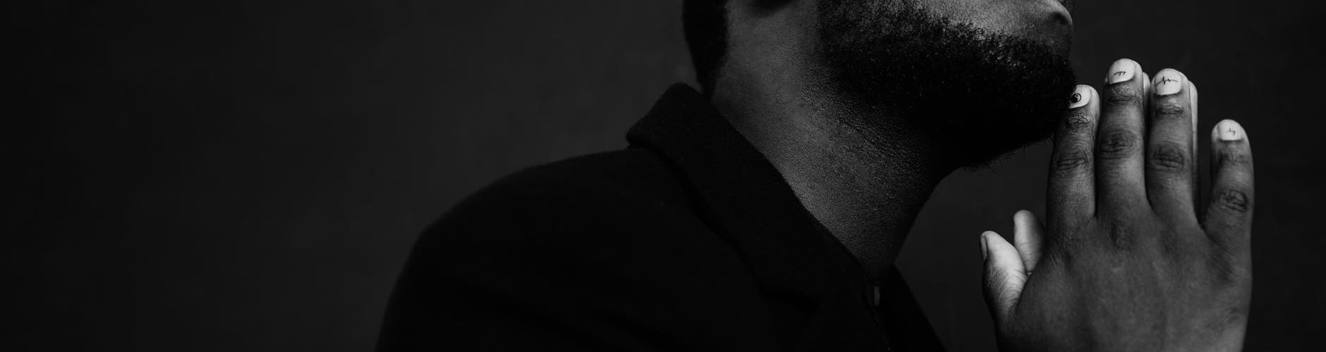 black man praying with eyes closed