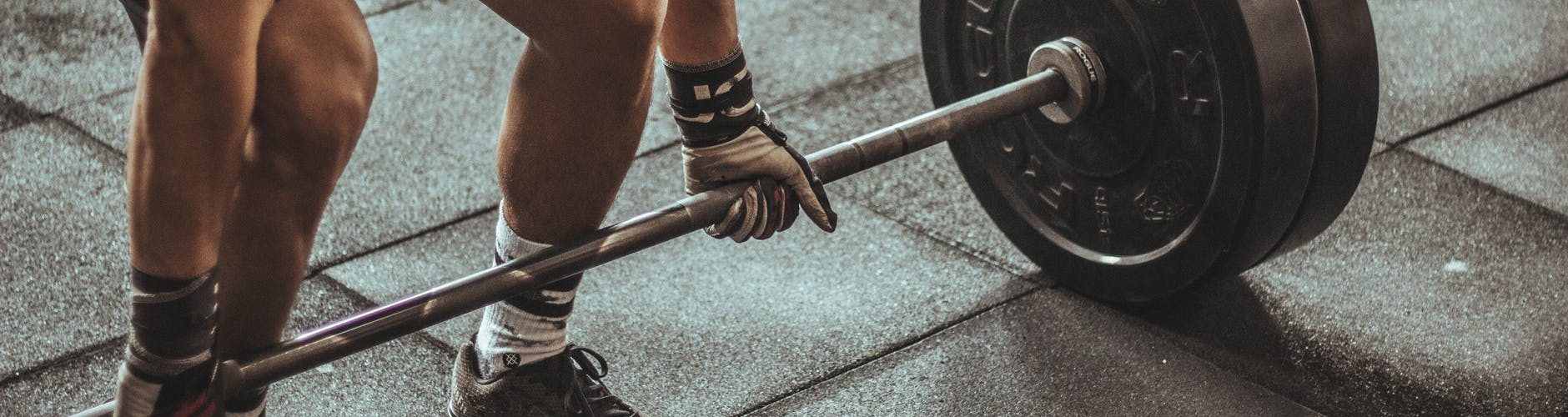 person holding black and silver steel barbell photography