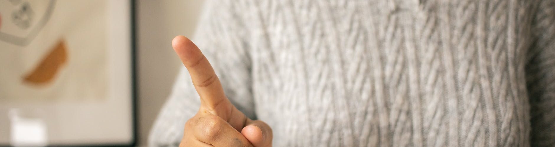 black woman pointing finger in light room