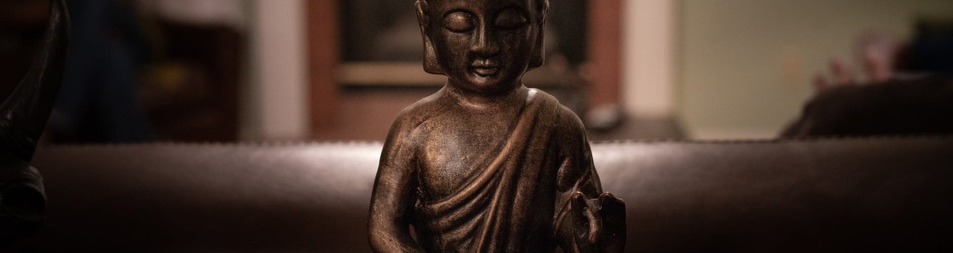 brass buddha figurine on black surface