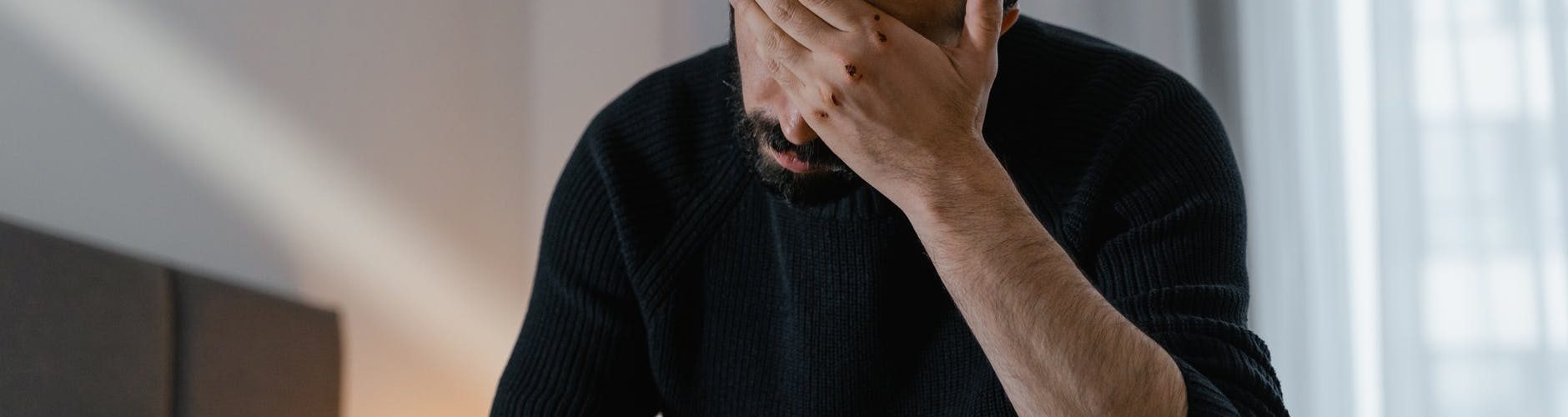 man in black sweater sitting on chair