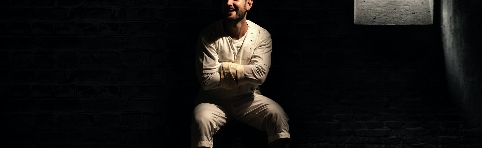 a crazy man sitting inside the cell