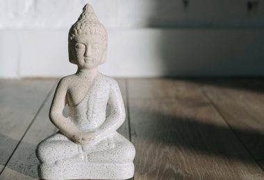 white ceramic angel figurine on brown wooden table