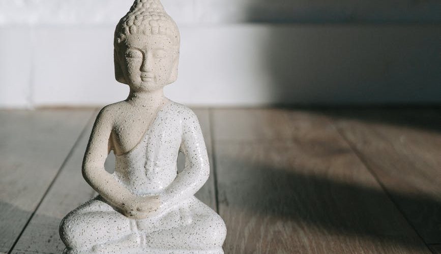white ceramic angel figurine on brown wooden table