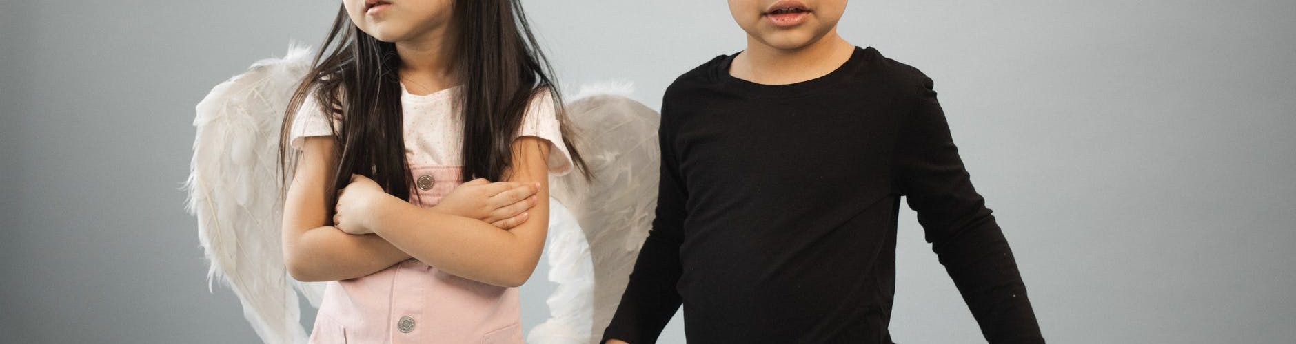 cute multiracial kids in angel and devil costumes