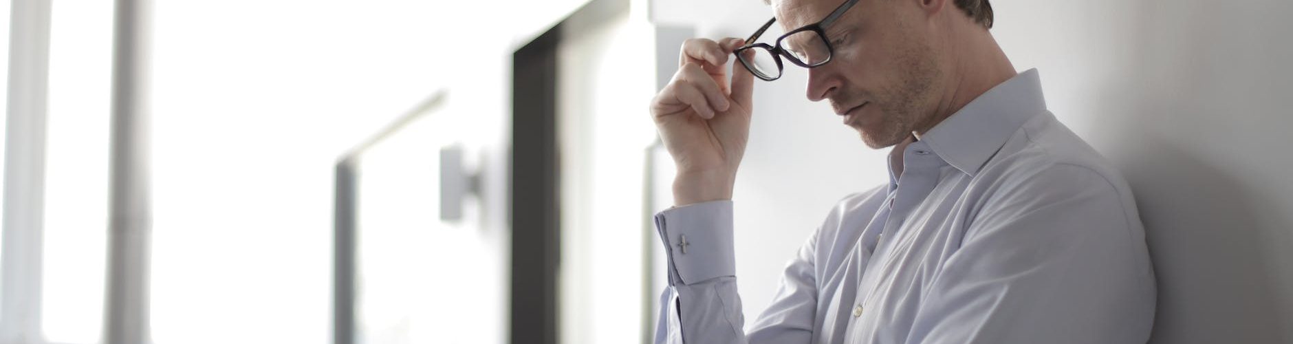 photo of man holding black eyeglasses