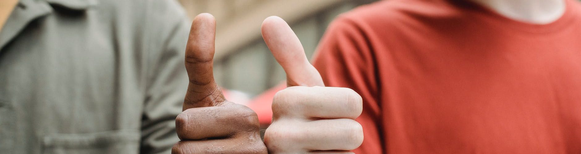 unrecognizable multiracial guys showing thumbs up gesture