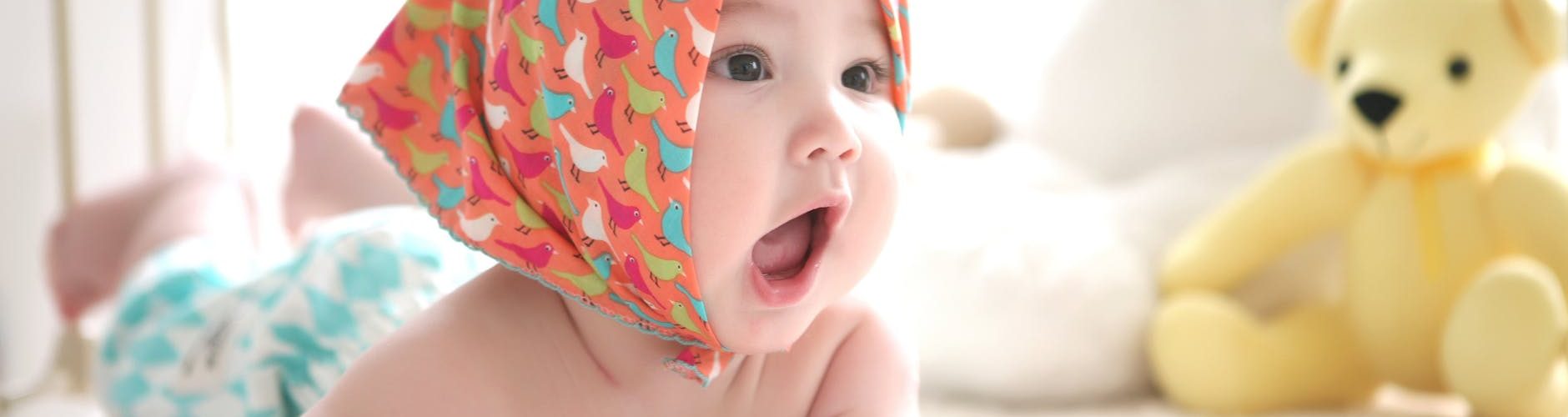 toddler wearing head scarf in bed