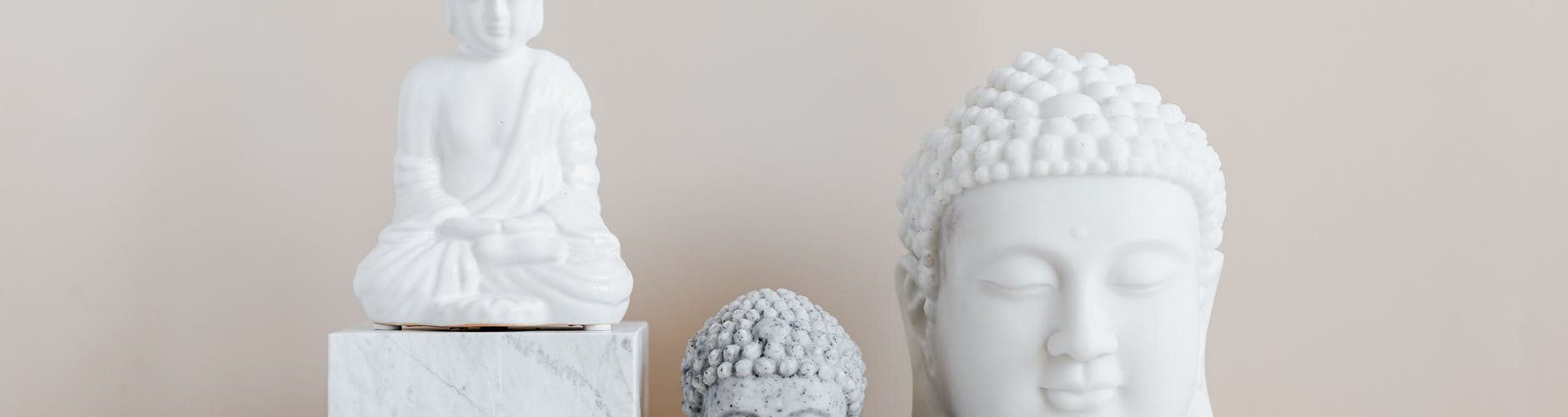 decorative statue and busts of buddha on beige background