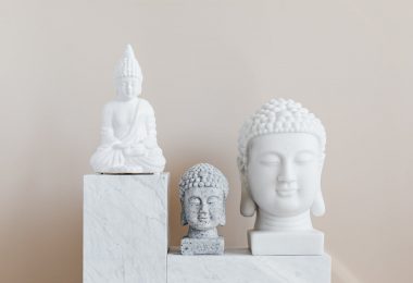 decorative statue and busts of buddha on beige background