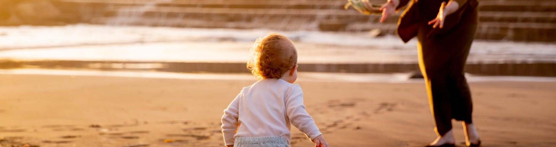 mother and child playing on the shore