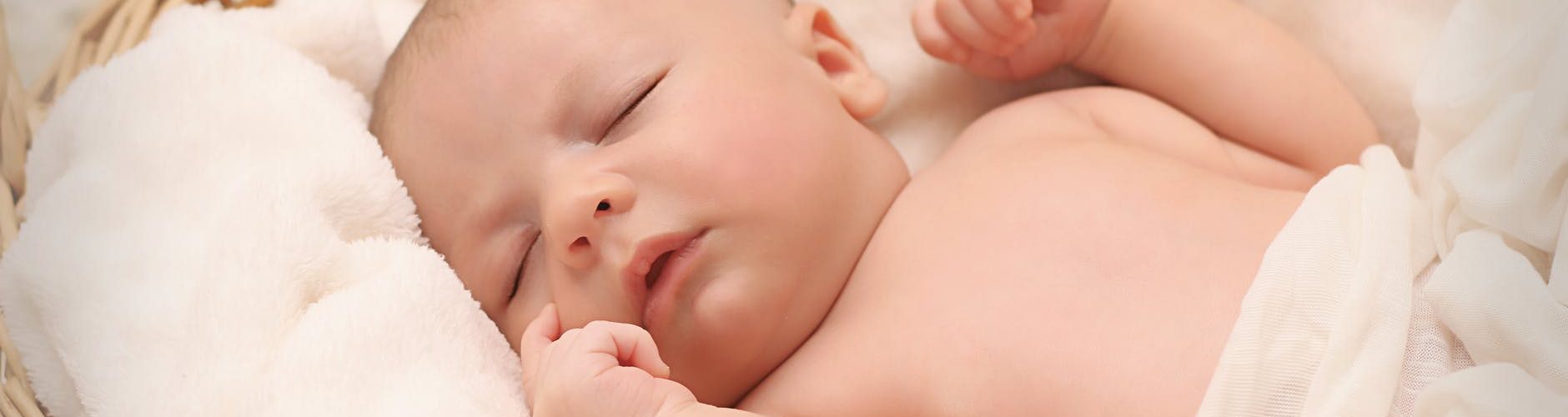 baby sleeping on white cotton