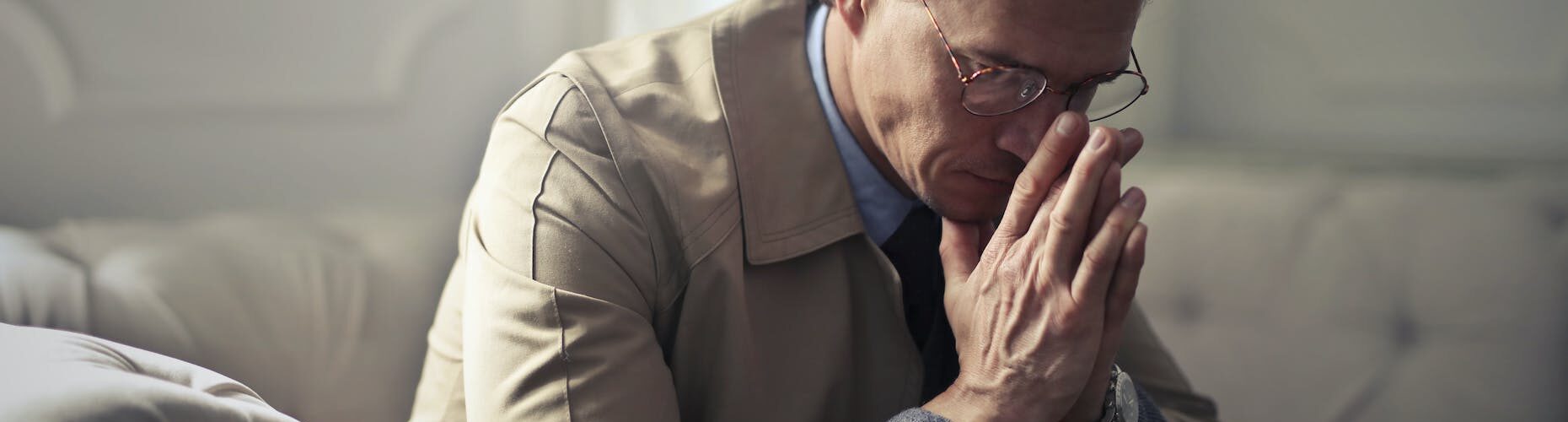 sad mature businessman thinking about problems in living room