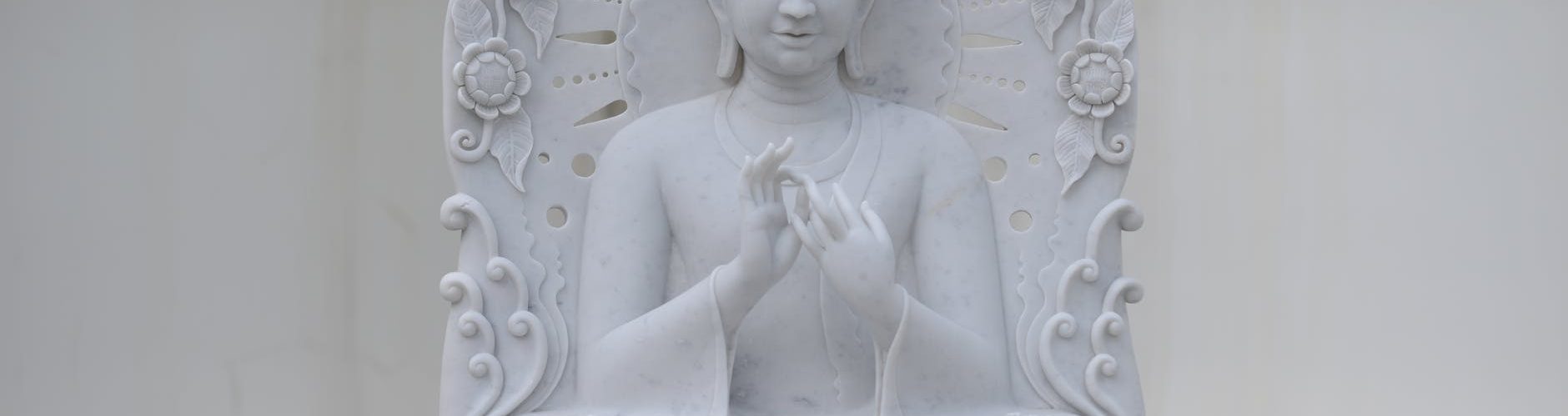 a sculpture of white marble gautam buddha