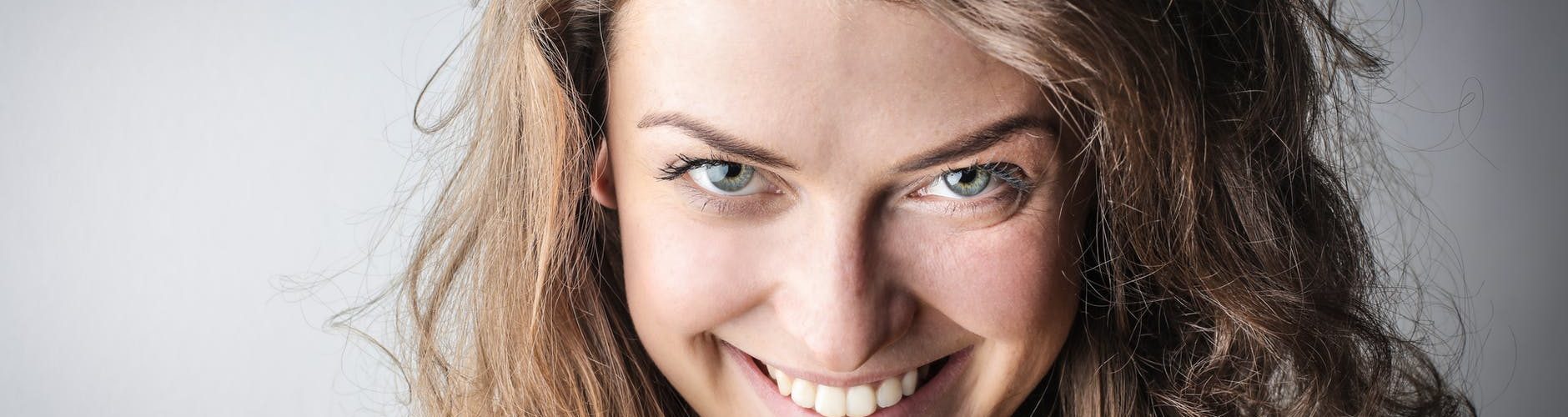 portrait photo of smiling woman in yellow sweater