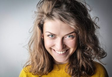 portrait photo of smiling woman in yellow sweater