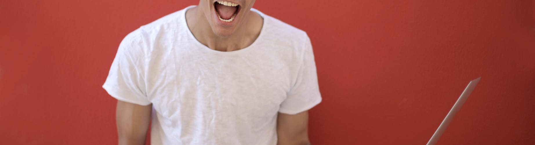 young ethnic male with laptop screaming