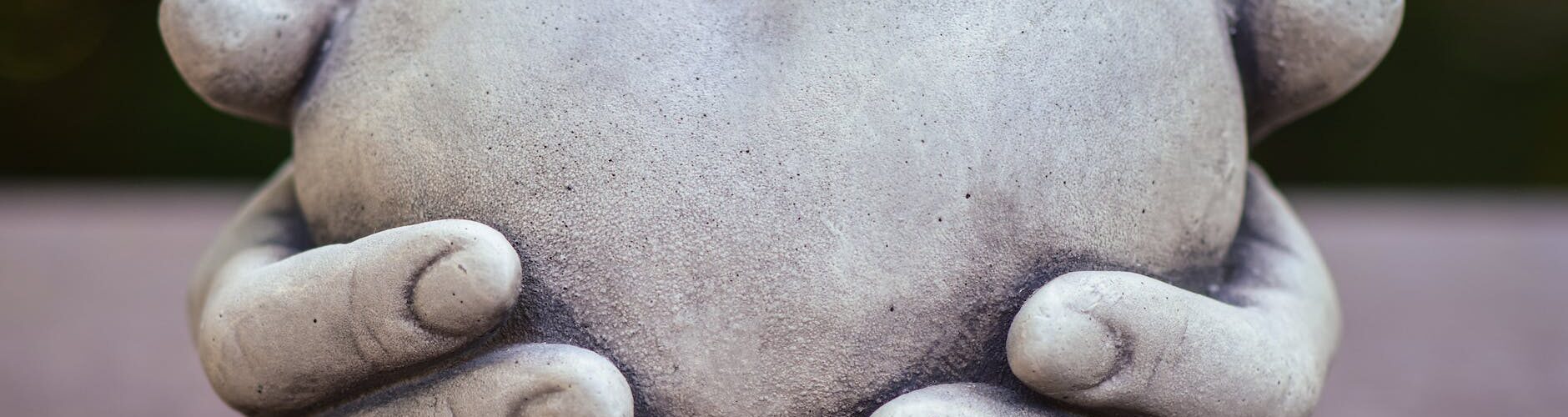 conceptual sculpture with hands holding a heart