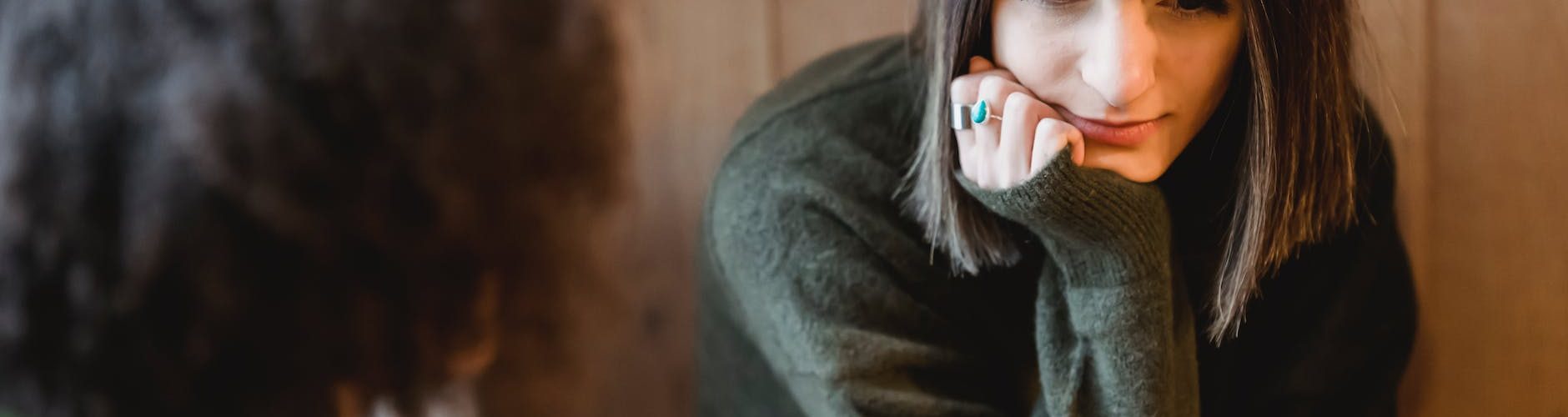 melancholic young woman communicating with anonymous black best friend at home