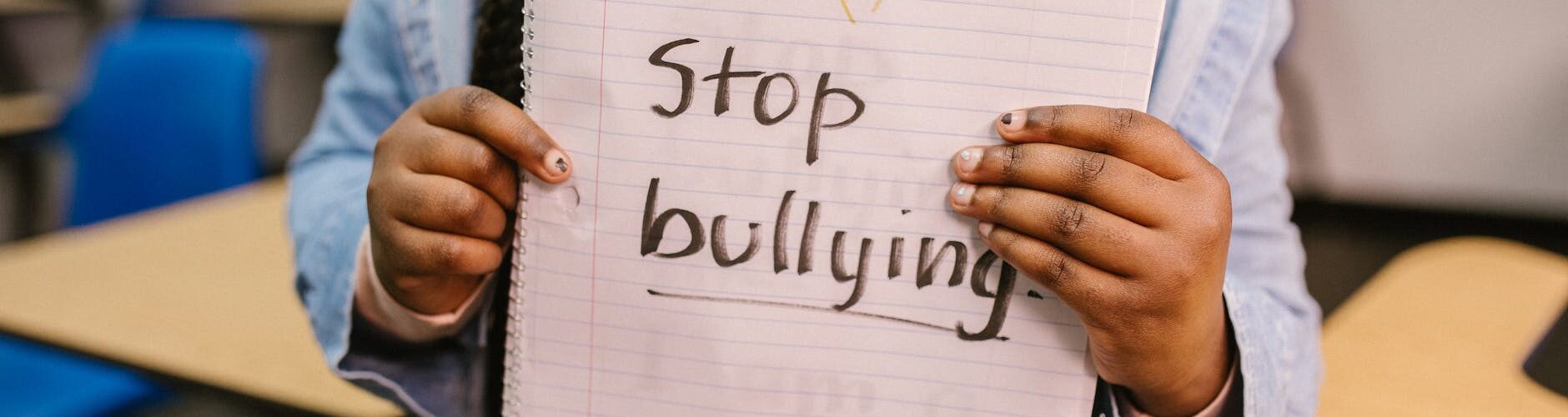 child showing a message written in a notebook
