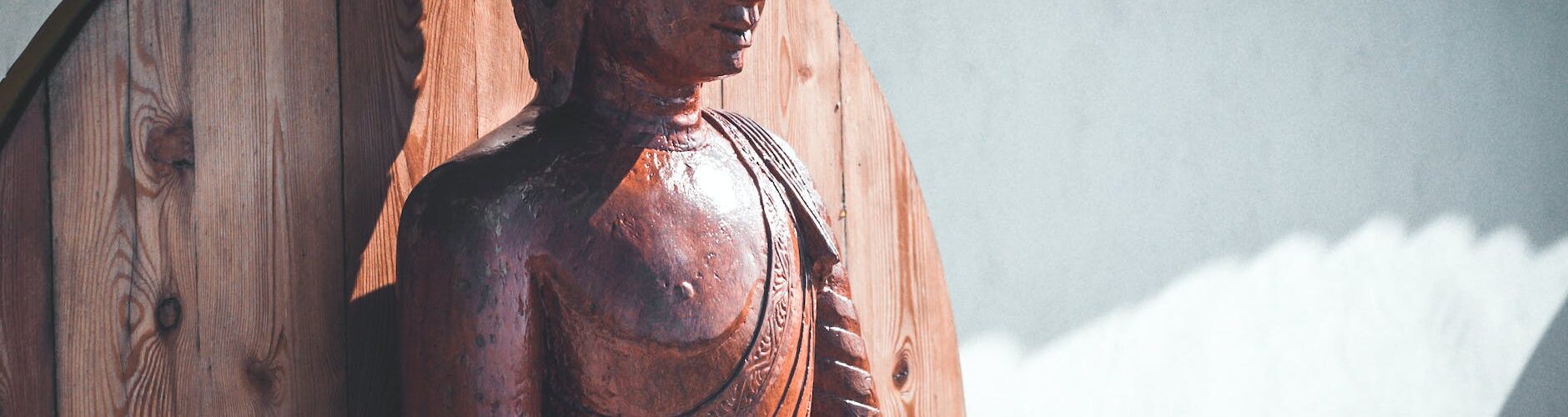a brown wooden statue of buddha