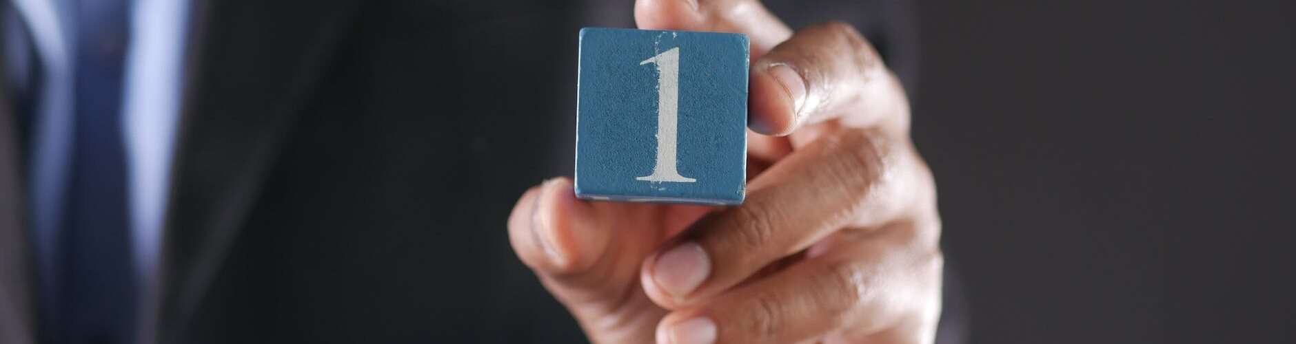a close up shot of a person holding a block with a number