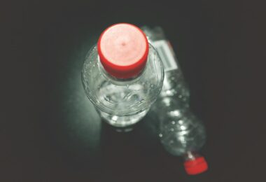 two clear plastic bottles on black surface