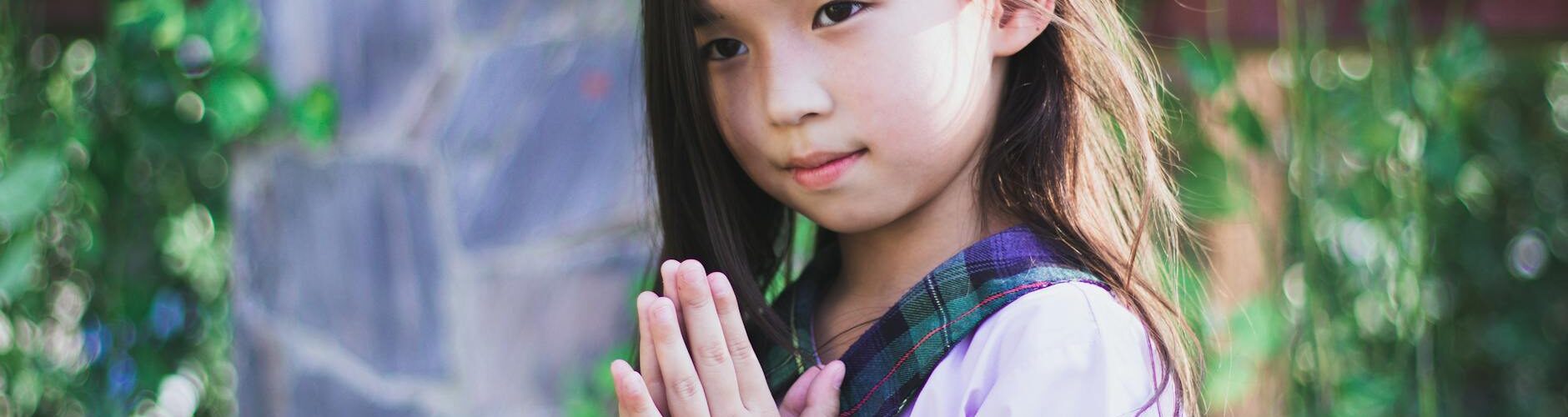 girl in purple short sleeve shirt with green and black plaid collar wearing black digital watch