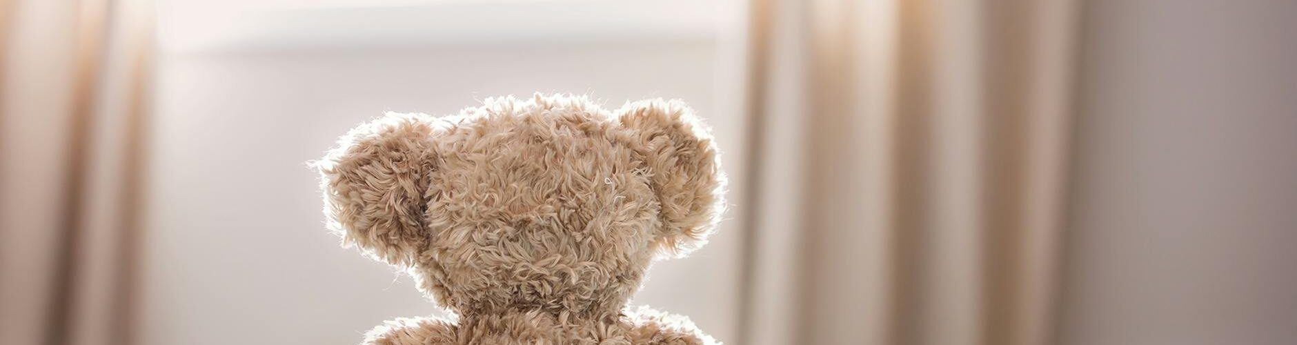 brown bear plush toy on bed