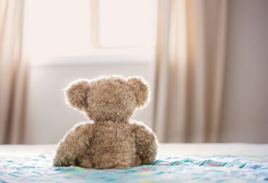 brown bear plush toy on bed