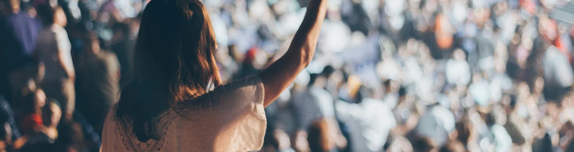 woman with white shirt raising her right hand