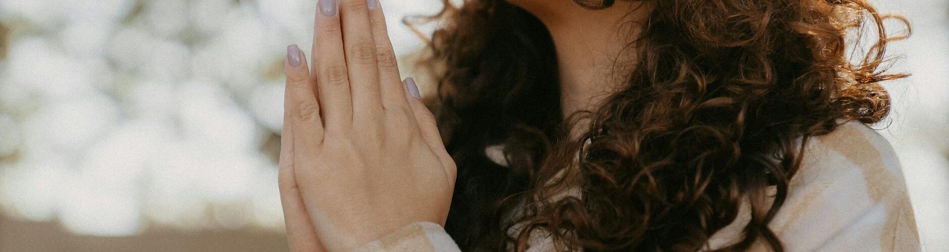 woman praying with hands clasped