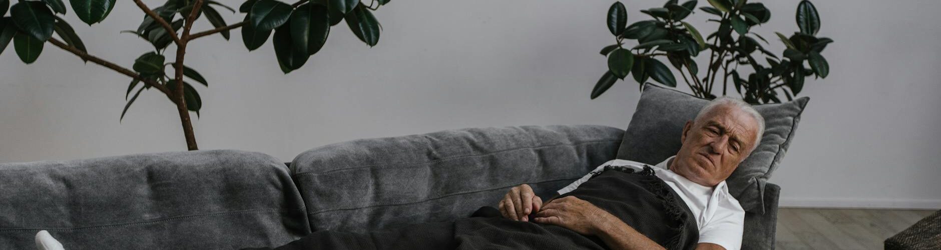 sick man sleeping on the gray sofa