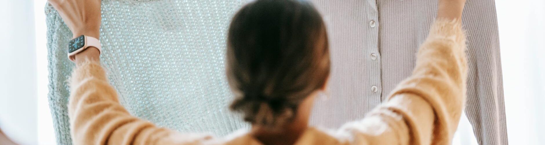 unrecognizable woman demonstrating clothes in store