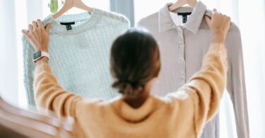 unrecognizable woman demonstrating clothes in store