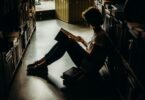 woman sitting on floor reading book