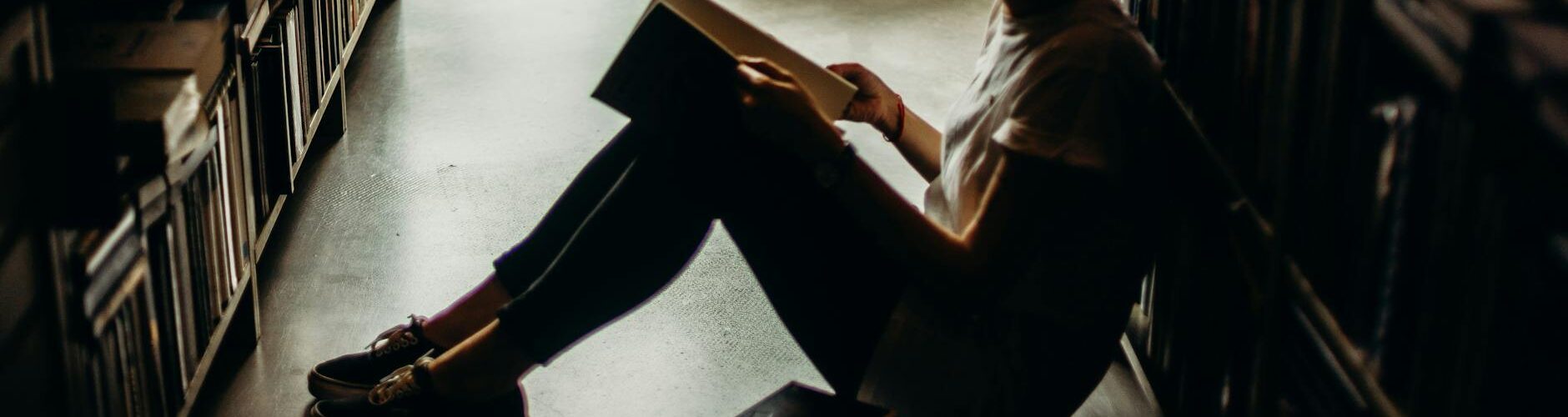 woman sitting on floor reading book