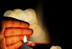 hand close to a lit diya