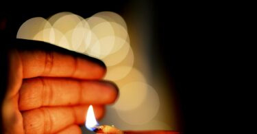 hand close to a lit diya