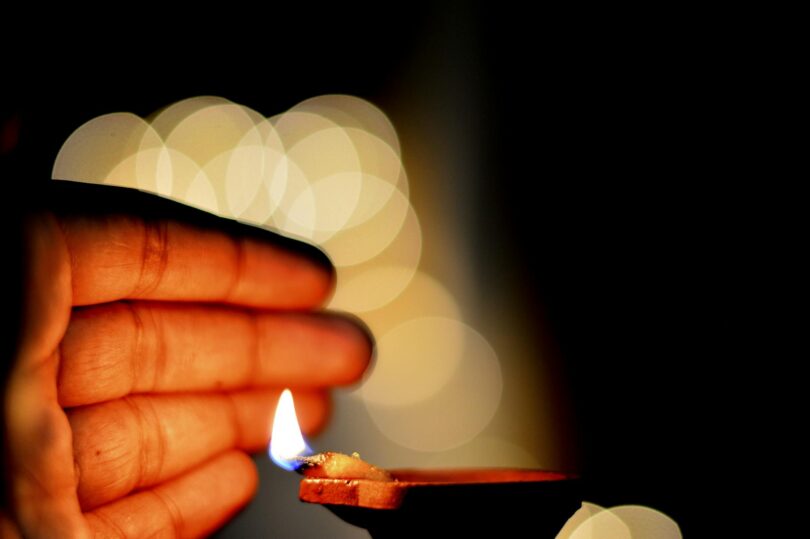 hand close to a lit diya